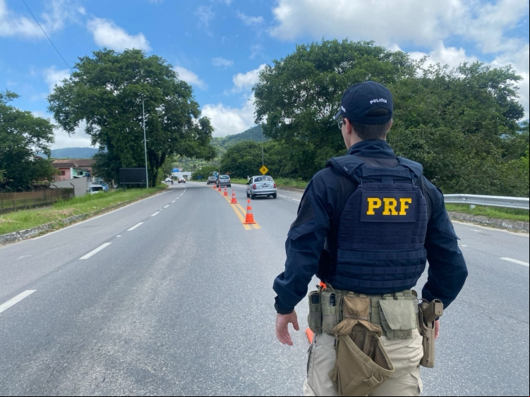 Policial rodoviário observa o movimento na rodovia durante a Operação Semana Santa 2025, que reforça a segurança e a fiscalização nas estradas paulistas durante o feriado prolongado.